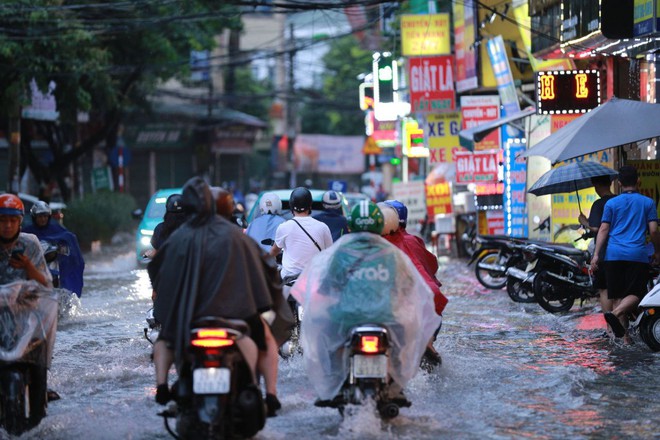 Mưa tầm tã đúng giờ tan tầm, nhiều tuyến phố Hà Nội ngập thành sông - Ảnh 1.