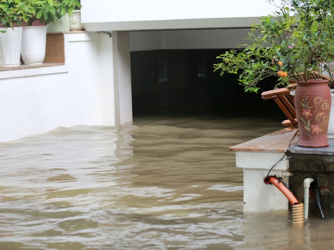 Trời hửng nắng, nhiều tuyến đường ở Hà Nội vẫn ngập sâu, người dân dùng tấm chắn để ngăn nước tràn vào nhà- Ảnh 5.