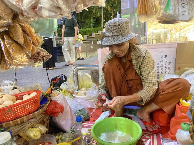 Gánh bánh tráng "bà chủ ngủ gục" độc lạ ở trung tâm TP.HCM: Khách tự trộn, tự trả tiền, thậm chí ngồi bán giùm- Ảnh 4. Gánh bánh tráng "bà chủ ngủ gục" độc lạ ở trung tâm TP.HCM: Khách tự trộn, tự trả tiền, thậm chí ngồi bán giùm- Ảnh 4.