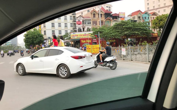 Clip: Hai bé gái thản nhiên ngồi vắt vẻo trên nóc ô tô đang đi trên đường