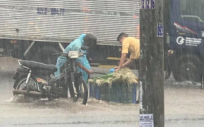 Biên Hòa: Chàng thanh niên phụ giúp người đàn ông bán rau giữa trời mưa to gió lớn