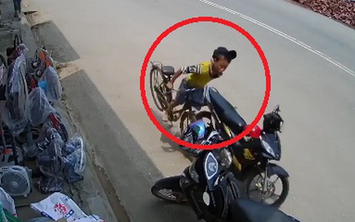 Clip: Cậu bé đi xe đạp ngã nhào khi tự đâm vào chiếc xe máy đỗ trên đường