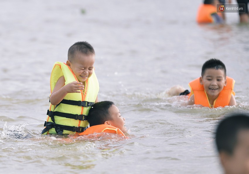 Chùm ảnh: Người lớn, trẻ nhỏ Hà Nội mặc áo phao ùa ra đường tỉnh lộ bơi lội, đánh cá sau nhiều ngày mưa ngập - Ảnh 9.