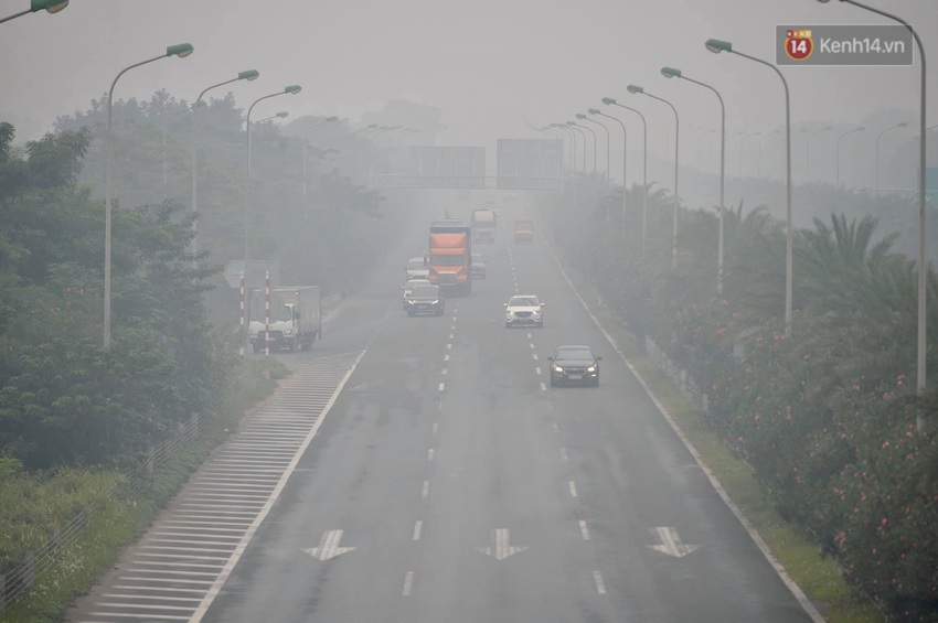 Chùm ảnh: Giữa trưa, nhiều tòa nhà cao tầng ở Hà Nội vẫn ẩn hiện trong lớp sương bụi mù mịt - Ảnh 8.