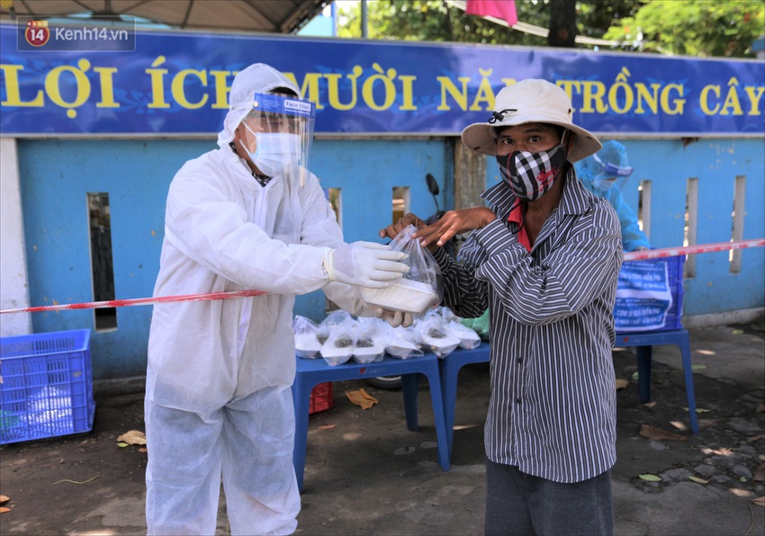 Sinh viên, người nghèo Đà Nẵng xếp hàng dài, cách nhau 2m chờ nhận cơm miễn phí trong dịch Covid-19 - Ảnh 3.