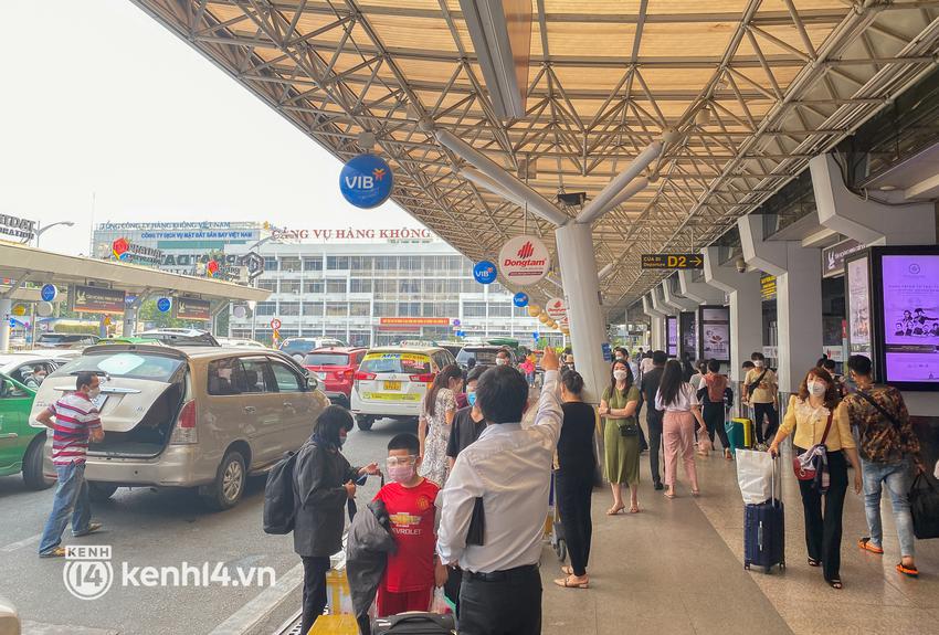 Ảnh, clip: S&acirc;n bay T&acirc;n Sơn Nhất nhộn nhịp người về qu&ecirc; đ&oacute;n Tết, h&agrave;nh kh&aacute;ch rồng rắn xếp h&agrave;ng d&agrave;i check in - Ảnh 4.