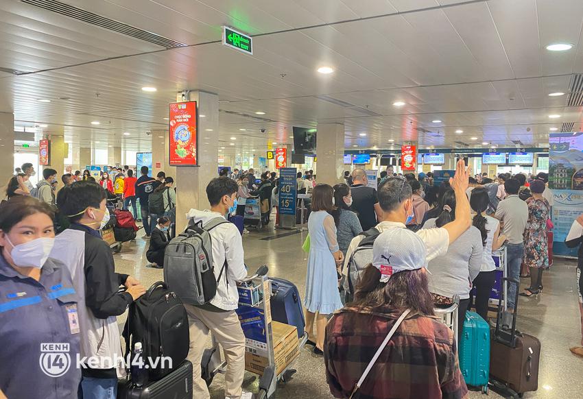 Ảnh, clip: S&acirc;n bay T&acirc;n Sơn Nhất nhộn nhịp người về qu&ecirc; đ&oacute;n Tết, h&agrave;nh kh&aacute;ch rồng rắn xếp h&agrave;ng d&agrave;i check in - Ảnh 14.