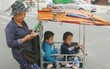 Đôi song sinh khuyết tật 14 tuổi hát cực hay, theo mẹ bán vé số khắp Sài Gòn: 