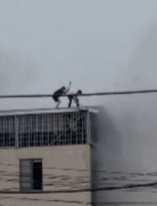 CLIP: Cận cảnh khoảnh khắc nghẹt thở khi 2 người đàn ông phá mái tôn mở đường sống trong đám cháy nhà 7 tầng ở Lĩnh Nam