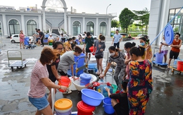 Ảnh: Người dân chung cư Hà Nội mang xô chậu đi lấy nước sạch để rửa bát, tắm gội