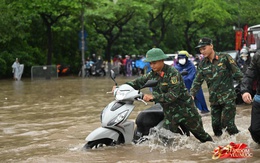 Ảnh đẹp sáng nay: Các chiến sĩ làm nhiệm vụ A80 lội nước đẩy xe, dìu dân qua đoạn ngập sâu ở Hà Nội