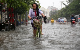 Học sinh ở Sài Gòn bì bõm lội nước sau giờ tan học do mưa lớn kéo dài từ sáng đến trưa