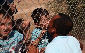 Người cha Syria hôn các con qua hàng rào sắt khi họ được đoàn tụ sau 1 năm xa cách vì khói lửa chiến tranh