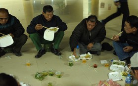 Nhiều người ngồi bệt ăn cơm, uống bia ngay tại sảnh trụ sở VFF chờ mua vé chung kết AFF Cup