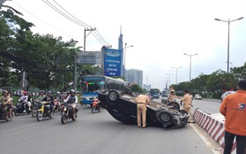 Xe ô tô đâm dải phân cách rồi lộn nhào, "ngửa bụng" trên đường phố Sài Gòn khiến nhiều người thót tim