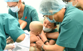 2 bé song sinh Diệu Nhi - Trúc Nhi đã bớt sốt, các bác sĩ tiến hành chuyển bé qua nệm chống loét, nhiễm trùng