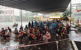 Người dân ở TP.HCM ngồi đợi dưới mưa để tiêm vaccine Vero Cell