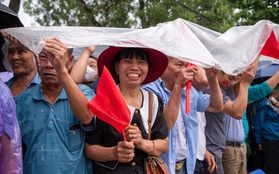 Bà con đội mưa ra đường, phấn khởi trong ngày diễu binh diễu hành kỷ niệm 70 năm Chiến thắng Điện Biên Phủ