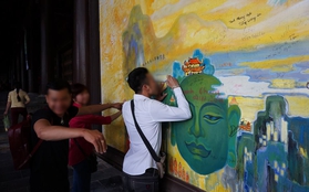 Du khách "hồn nhiên" ký tên, vẽ lên bức tranh in hình Phật ở chùa Bái Đính