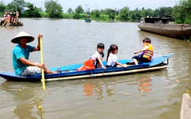 Trẻ em ngồi thuyền vượt dòng nước chảy xiết để đi học ở Sài Gòn