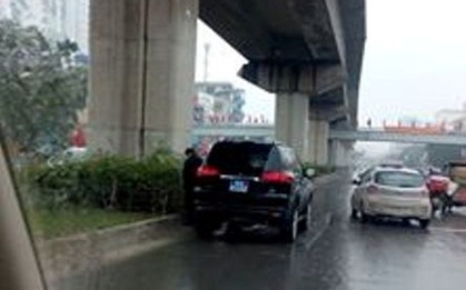 Người đàn ông đứng cạnh xe biển xanh tiểu bậy giữa đường