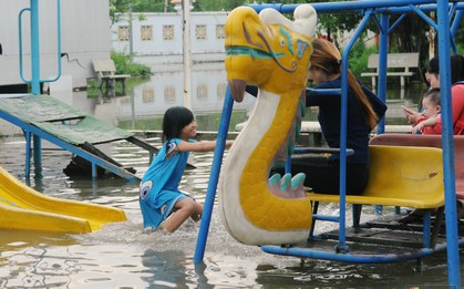 Trẻ em thích thú nô đùa tại khu vui chơi ngập nặng vì triều cường dâng cao ở Sài Gòn