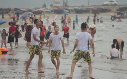 Trời vừa ngớt mưa, hàng nghìn du khách liền ùa xuống bãi biển Cửa Lò tắm mát