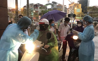 Cán bộ nhân viên BV Bạch Mai đội mưa kiểm tra thân nhiệt từng người vào viện, ngừng khám theo yêu cầu để chống dịch COVID-19