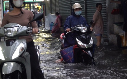 TP.HCM: Người dân vật lộn tát nước ra khỏi nhà vì triều cường kèm mưa lớn