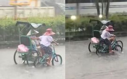 Xúc động em nhỏ còng lưng đạp xe, đẩy xe người khuyết tật khi mưa to, đường ngập