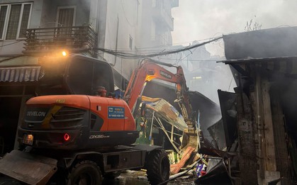 Dùng máy xúc phá dỡ, mở đường cho cảnh sát dập tắt đám cháy chợ ở Hà Nội