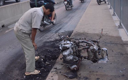 Người đàn ông thẫn thờ bên chiếc xe bốc cháy trơ khung ở Sài Gòn