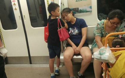 Cậu bé "soái ca" nhường ghế cho phụ nữ, lấy tay làm gối đỡ cho mẹ ngủ trên tàu điện ngầm