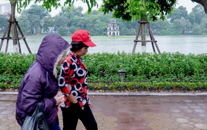 Trời trở lạnh 20 độ C kèm mưa nặng hạt, người Hà Nội khoác áo ấm ra đường