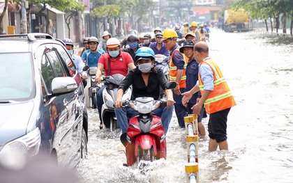 Sài Gòn ngập cả buổi sáng sau trận mưa đêm, nhân viên thoát nước ra đường đẩy xe chết máy giúp người dân