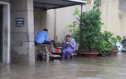 Chùm ảnh: Người Hà Nội mặc áo mưa ăn trưa giữa đường phố ngập lênh láng