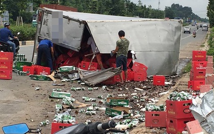 Bình Dương: Xe tải cày nát thành cầu rồi lật ngang đường, người dân đến thu gom bia giúp tài xế