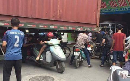 Bất chấp nguy hiểm, người dân thi nhau chui gầm container chắn ngang giữa đường để lưu thông