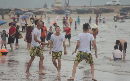 Trời vừa ngớt mưa, hàng nghìn du khách liền ùa xuống bãi biển Cửa Lò tắm mát