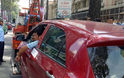 Tài xế "cố thủ", hút thuốc trong ô tô dù xe bị kéo đi vì đậu sai quy định