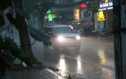 Giữa ban ngày mà Sài Gòn bỗng tối sầm vì mưa lớn, người dân phải bật đèn di chuyển trên đường