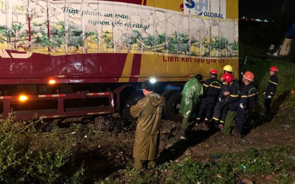 Sau tai nạn, cả tài xế và xe máy bị cuộn trong gầm container