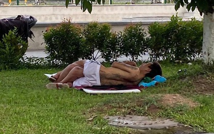 Hình ảnh cặp đôi ăn mặc mát mẻ, vô tư nằm ôm ấp nhau ngoài bãi cỏ giữa cái nắng nóng 40 độ khiến nhiều người khó chịu