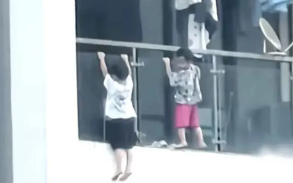 2 đứa trẻ vắt vẻo ngoài lan can tầng 13