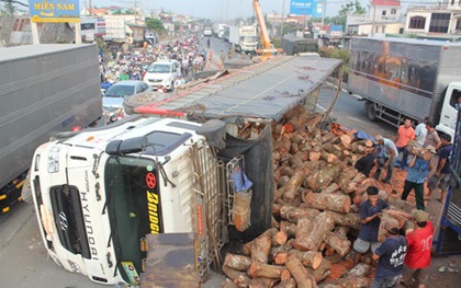 TP.HCM: Xe tải lật nhào, hàng chục tấn gỗ ào xuống đường