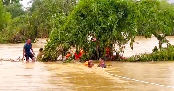 Cảnh sát căng dây, ngâm mình trong nước lũ giải cứu 22 người mắc kẹt trong bão số 10